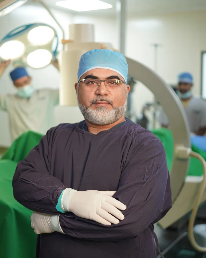 Dr Imran Salim Malik in the operating theatre, arms folded