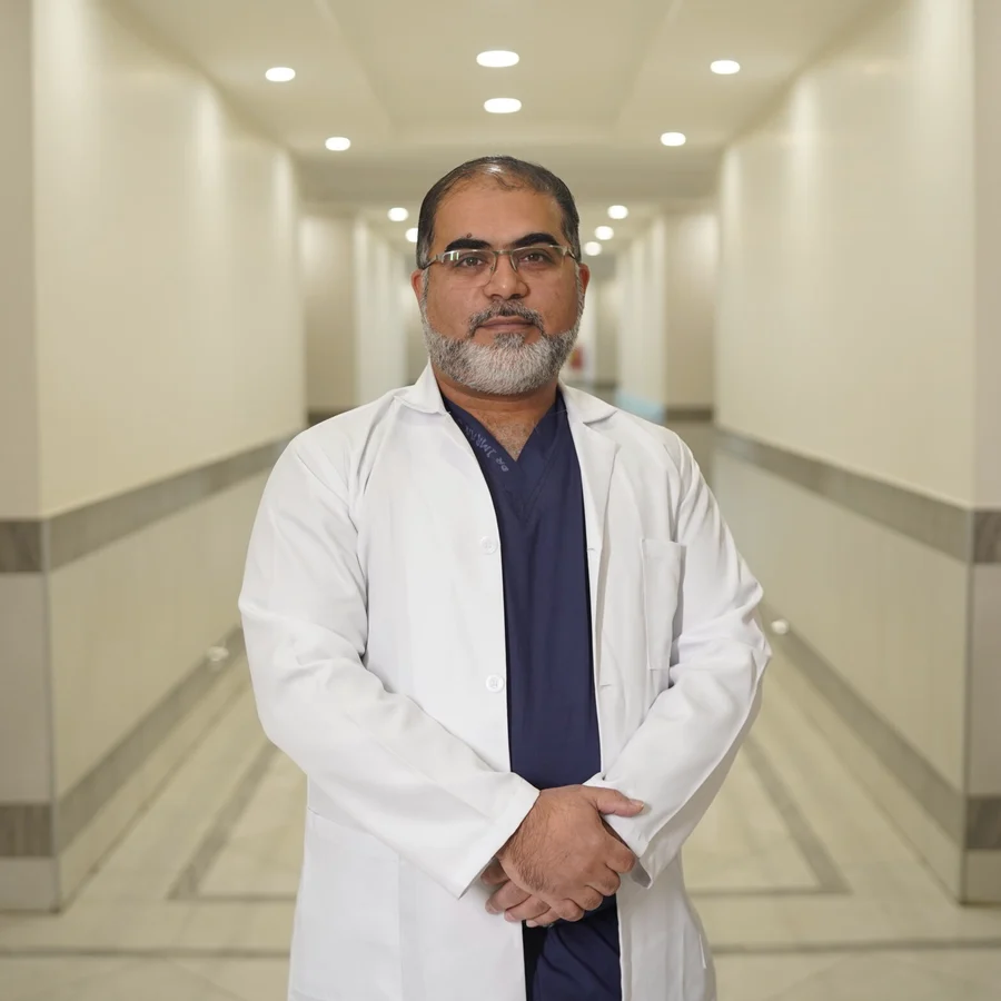 Dr Imran Salim Malik in a white coat in a hospital corridor